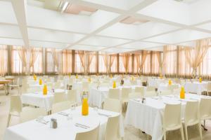 a banquet hall with white tables and white chairs at HI - Tel Hai Hostel in Tel H̱ay +16 photos