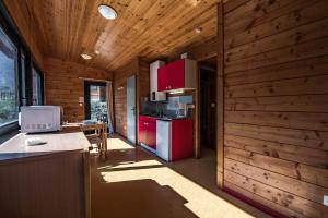 a kitchen with red cabinets and a table in a house at Les Chalets by Le Marintan in Saint-Michel-de-Maurienne