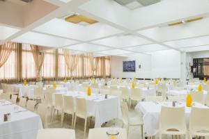a large room with white tables and chairs at HI - Tel Hai Hostel in Tel H̱ay