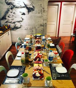 a long table with plates and food on it at DAB Guest House in Rome