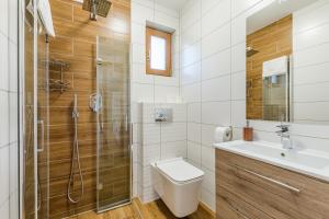 a bathroom with a shower and a toilet and a sink at Apartamenty na Spacerowej in Dębki +29 photos