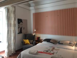 a bedroom with a large bed and a chair at DAB Guest House in Rome