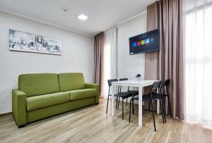 a living room with a green couch and a table at GBH Hotel-Apartamentos Caballito de Mar in Benidorm