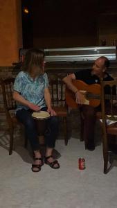 een man die gitaar speelt en een vrouw die voor een piano zit bij Albergue Ciudad del Doncel in Sigüenza