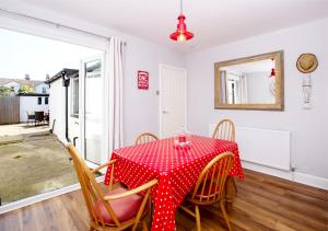 ein Esszimmer mit einem roten Tisch und Stühlen in der Unterkunft Seashell Cottage in Deal