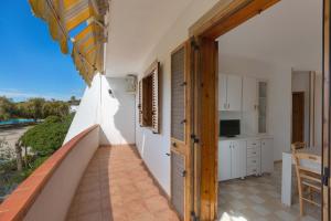 a room with a balcony with a table and a kitchen at Casa Di Ronzino by BarbarHouse in San Foca