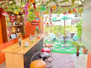 a restaurant with a bar with stools and flowers at Orange House in Osaka