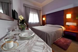a hotel room with a bed and a table with a plate at Hotel Roma Tiburtina Metro in Rome