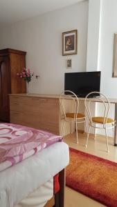 1 dormitorio con 2 sillas y escritorio con TV en Pension Óvári, en Bük