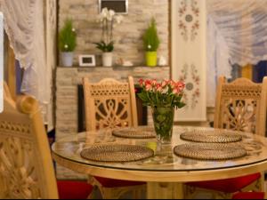 stół z krzesłami i szklany stół z kwiatami w obiekcie Luksusowe Domki Elizy Luxury Chalets Poronin w mieście Suche