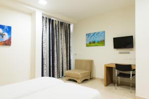 a bedroom with a bed and a desk and a tv at HI - Poriya Hostel in Poriyya