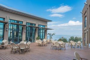 a deck with chairs and tables on a building at HI - Poriya Hostel in Poriyya Illit