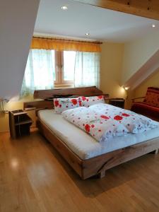 a bedroom with a large bed with red flowers on it at Ortnerhof in Millstatt