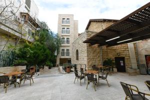 an outdoor patio with tables and chairs and a building at HI Agron - Jerusalem Hostel in Jerusalem
