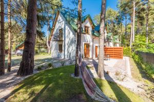 a house with a hammock in front of it at Apartamenty na Spacerowej in Dębki