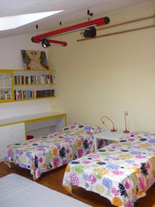 una camera con due letti, un tavolo e una libreria di Il Giardino Segreto a Imola