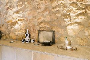 a stone wall with a counter top with a mirror and a mortar and pestle at The Old Cottage in Sencelles
