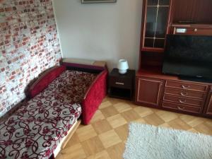 a bedroom with a bed and a flat screen tv at Słoneczny apartament z balkonem in Gdańsk