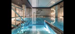 a swimming pool with blue water in a building at Deo Plaza by Blue Mandarin in Gdańsk