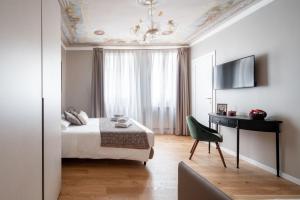 Dormitorio con cama, escritorio y TV en Locanda Herion, en Venecia