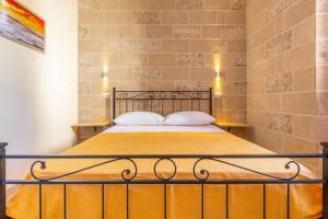 Bett in einem Zimmer mit Ziegelwand in der Unterkunft Casina Sofia by BarbarHouse in Leverano