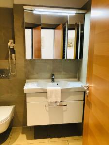 bagno con lavandino e specchio di Hotel Verdi a Monaco