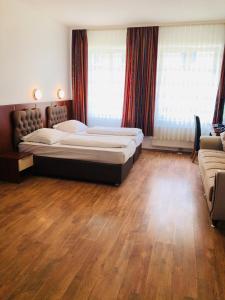 um quarto com 2 camas e piso em madeira em Hotel Verdi em Munique
