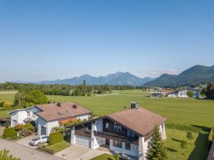 an aerial view of a house with a field and mountains at Direkt zwischen Chiemsee u Alpen Dg in Bernau am Chiemsee