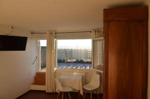 a room with a table and chairs and a window at Hôtel Restaurant Panoramique César in Bonnieux