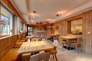 ein Restaurant mit Holzwänden sowie Holztischen und -stühlen in der Unterkunft Oberjahrl in St. Johann im Ahrntal