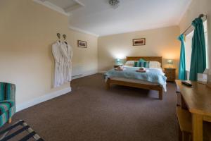 a bedroom with a bed and a dress hanging on the wall at Host & Stay - Poppy Cottage in Bamburgh