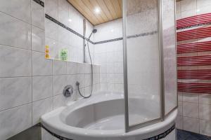 a bathroom with a tub with a glass shower at Zwischen Chiemsee und Bergen Ug in Bernau am Chiemsee