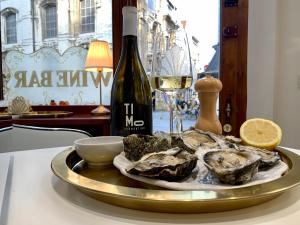 un piatto di ostriche e una bottiglia di vino su un tavolo di Olives a Bruxelles