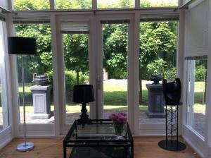 赫爾斯的住宿－B&B de Tol，客厅设有玻璃桌和窗户。