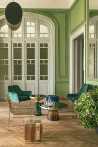 una sala de estar con paredes y sillas verdes y una mesa. en Aristide Hotel - Small Luxury Hotels of the World en Ermoupoli