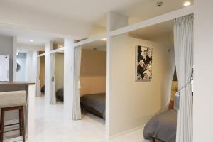 a bedroom with two beds and a desk in a room at コンドミニアムHARU 那覇県庁前 201 in Naha