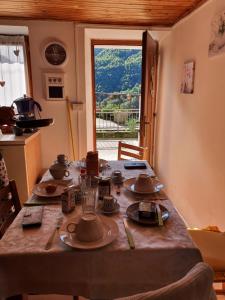 a table with plates and dishes on it in a kitchen at Coccinella House in Calasca Castiglione