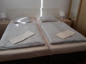 2 camas con toallas y almohadas encima de ellas en Apartmán SLAVKOV, en Nová Lesná