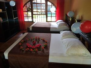 Habitación con 2 camas y una tarta en una mesa. en Hotel El Paraiso Escondido - Costa Rica, en Jacó