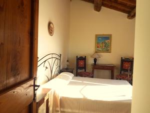 um quarto com uma cama branca e 2 cadeiras em Agriturismo San Cristoforo di Marco e Andrea em Amelia