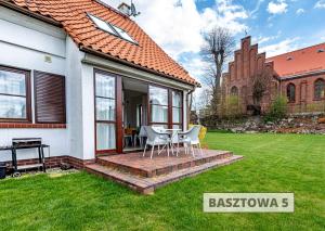 a house with a patio with a table and chairs at ApartView na Mazurach "Osada Zamkowa" by Rent like home in Pasym