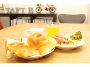 a table with two plates of food and a drink at Business Inn Norte 2 in Sapporo