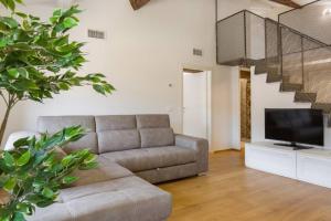 Luxury Design Apt with Amazing View في فيرونا: غرفة معيشة بها أريكة وتلفزيون