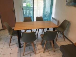 una mesa de madera y sillas en una habitación en Appartement Solférino en Luz-Saint-Sauveur