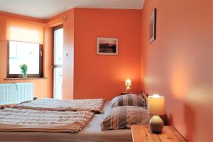 a bedroom with orange walls and two beds in it at Willa Solaris Łeba in Łeba