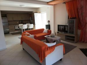 a living room with two couches and a tv at Loukas House 1Σταυρος-Κερκυρα Μακράτα in Stavrós