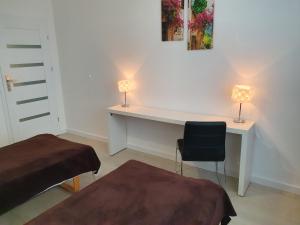 sypialnia z biurkiem z 2 lampami i krzesłem w obiekcie Apartament na Lazurowej w Warszawie