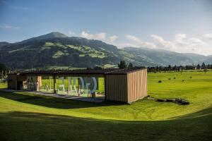 ein Haus auf einem Feld mit einem Berg im Hintergrund in der Unterkunft Chalet Tirol in Westendorf