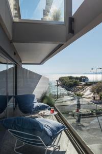uma varanda com cadeiras e vista para o oceano em Urban Suites em Atenas