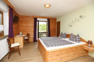 een slaapkamer met een bed, een bureau en een raam bij Pension Bergsee in Bad Wiessee